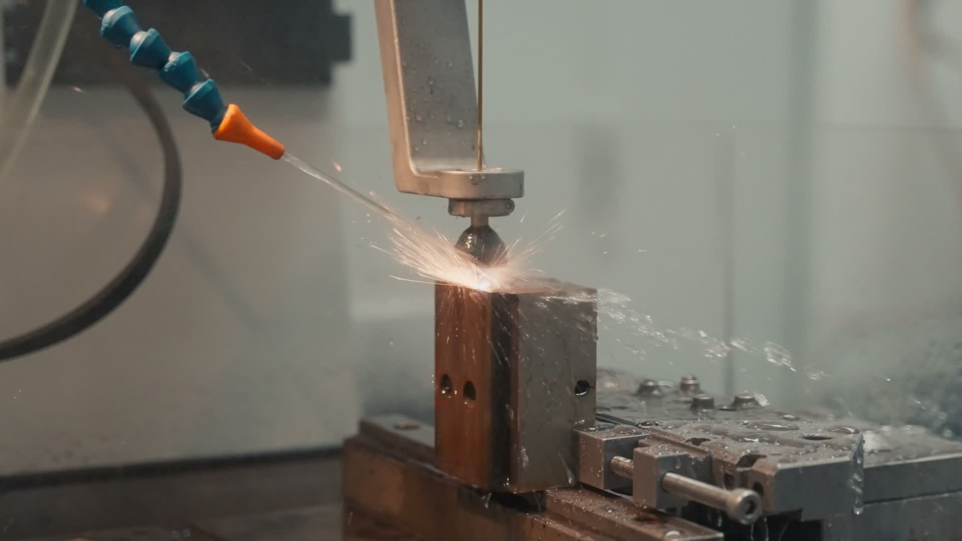 Funken und Kühlflüssigkeit an einer Kupferelektrode in einer Erodiermaschine im Werkzeugbau von Friedrich Joerg